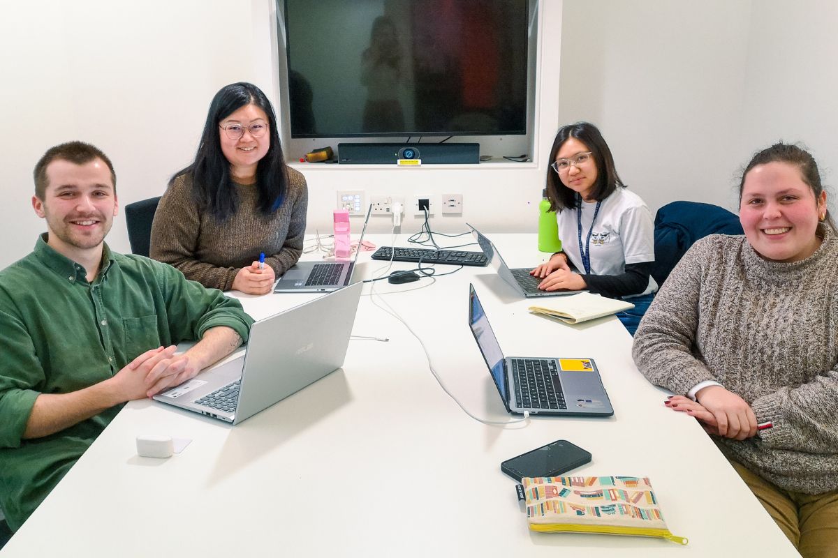 Four students sitting at a desk
